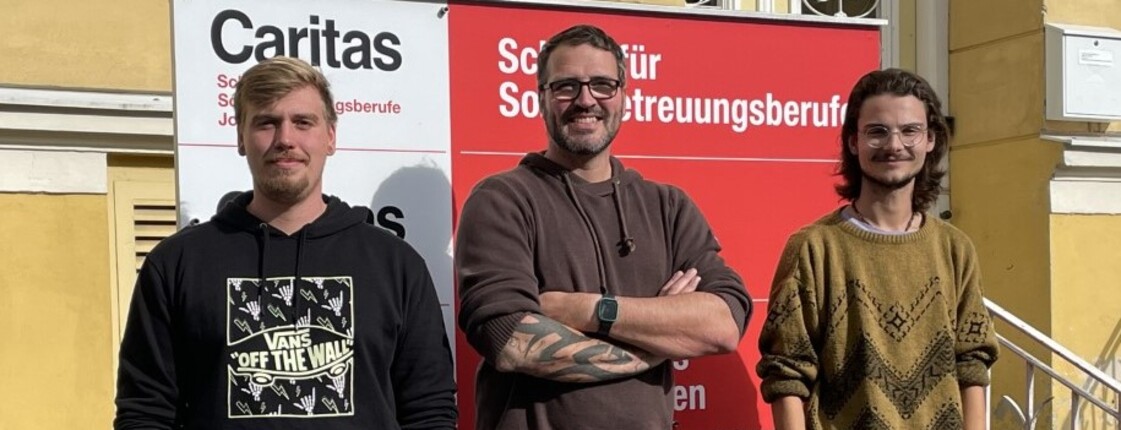 Drei Männer stehen nebeneinander und sehen in die Kamera.
